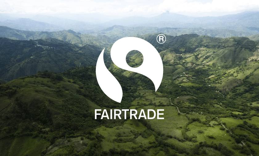 the logo for fairtrade is shown above green hills